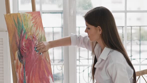 Inspirited Woman Applies Paint on Canvas Drawing Picture