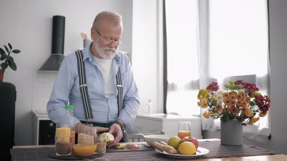 Elderly Attractive Grandfather with Beard in Glasses and Takes Care of His Health and Prepares a