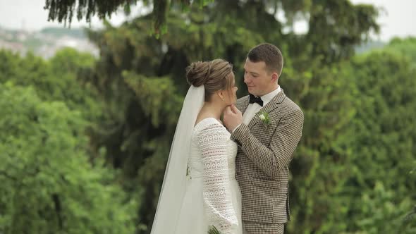 Newlyweds. Caucasian Groom with Bride Stay in Park. Wedding Couple. Man and Woman in Love