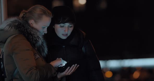 Women with Digital Tablet in Evening Street