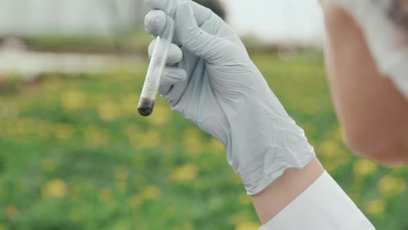 Scientist Examining Soil Mix in Test Tube