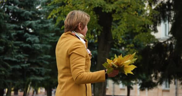 Beautiful Mature Woman Talking on Phone Walking in Autumn Park