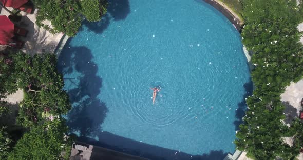 Shot of Circle Swimming Pool at the Tropical Resort with Swimming Female Inside