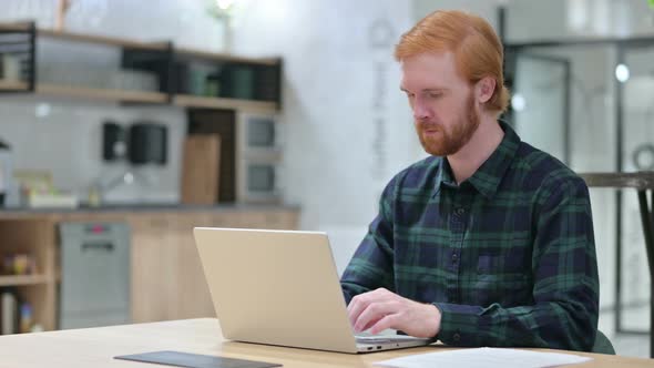 Young Beard Redhead Man in Cafe Using Laptop 