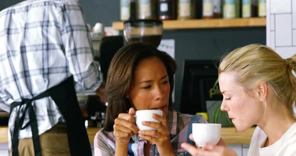 Women interacting with each other while having coffee