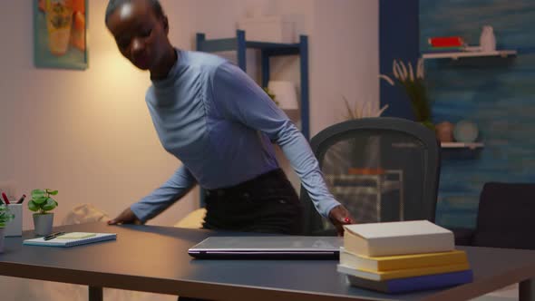 African Woman Coming in Living Room and Typing on Computer