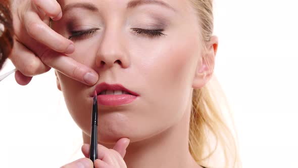 Makeup Artist Applying Lip Gloss To Model Lips