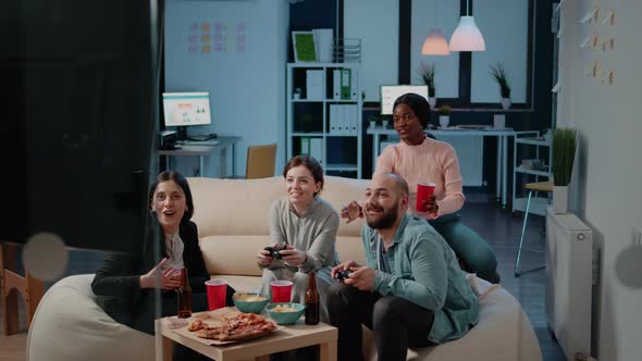 Coworkers Playing Video Games with Controllers on Console