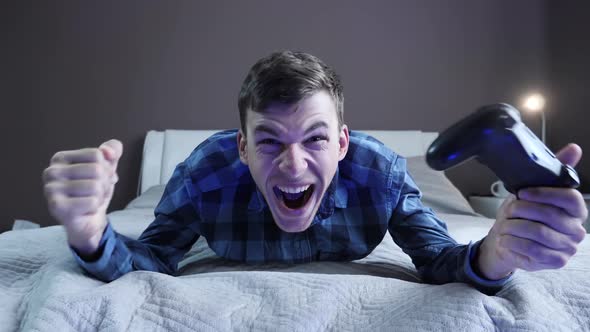 Male gamer playing and winning video game