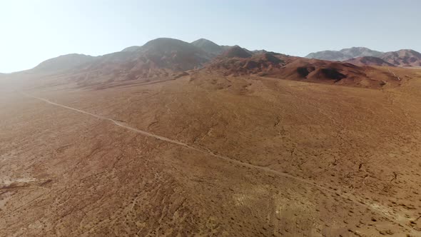 Aerial shots of the barren, sandy, rocky, mountain filled, Mojave Desert on a sunny day.