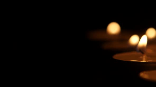 Small Candles Burning on a Dark Background. Movies To the Right
