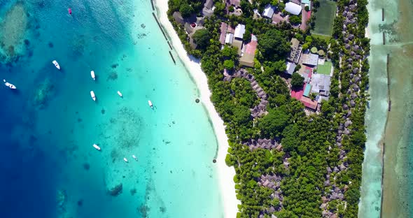 Luxury birds eye tourism shot of a white sand paradise beach and blue ocean background in colorful 4