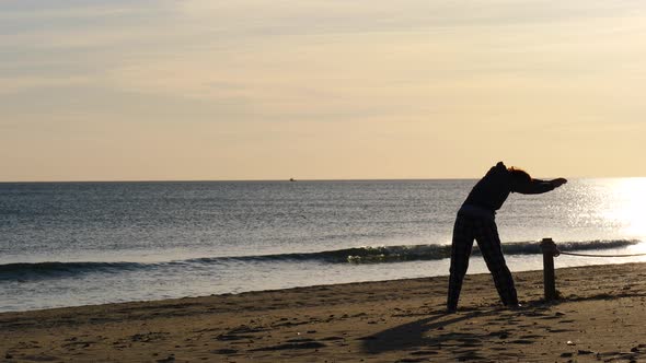 Woman Exercising on Beach at Morning.