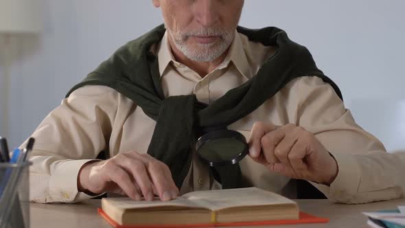 Senior Man Reading Book Through Magnifying Glass, Vision Disorders in Old Age