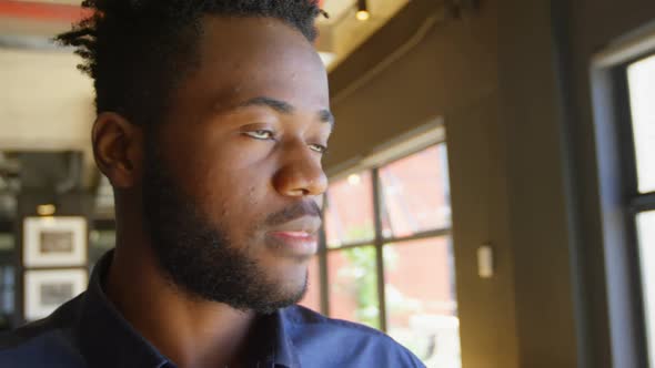 Front view of happy young black businessman looking at camera in a modern office 4k