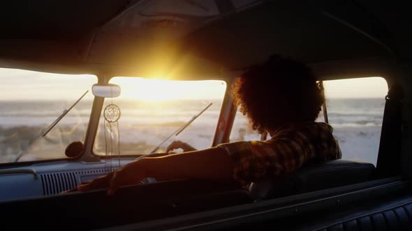 Man relaxing in camper van at beach 4k