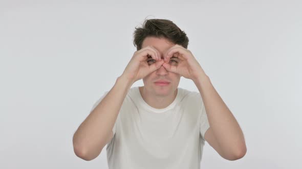 Searching Young Man with Binocular Gesture on White Background