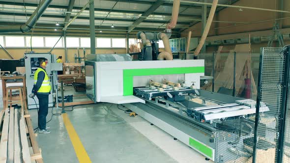 Engineer Checks Woodworking Machine at a Factory.