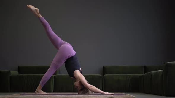 Lonely Woman in Sportswear Doing Side Plank in a Spacious Yoga Studio