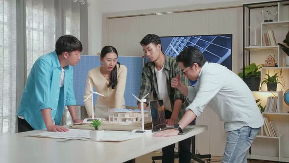 Man And Woman In Engineering Group Arguing During A Meeting About Small House Model With Solar Panel