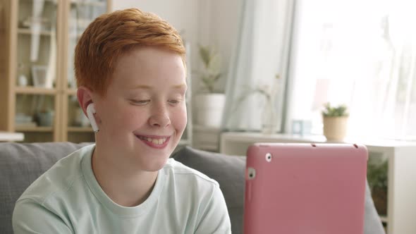 Teen Boy Chatting with Friend Using Tablet