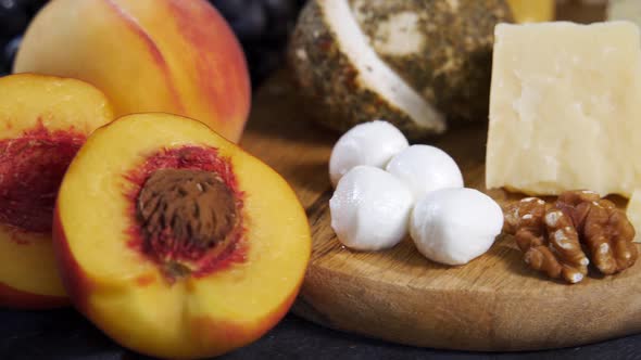 Cheese and Fruits are Spinning on a Wooden Board