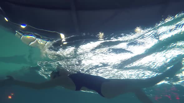 Female Swimmer Practicing Backstroke