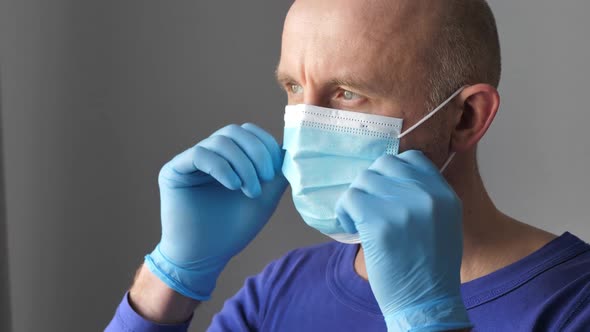 Confident Young Surgeon Doctor in Latex Protective Gloves Wearing Medical Mask on Face