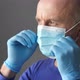 Confident Young Surgeon Doctor in Latex Protective Gloves Wearing Medical Mask on Face - VideoHive Item for Sale