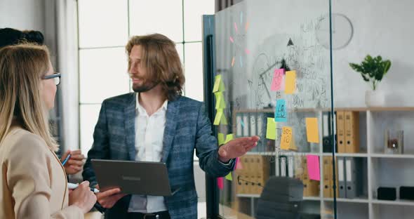 Coworkers which Lively Discussing Creative Ideas of Start Up Project Near Glass wall