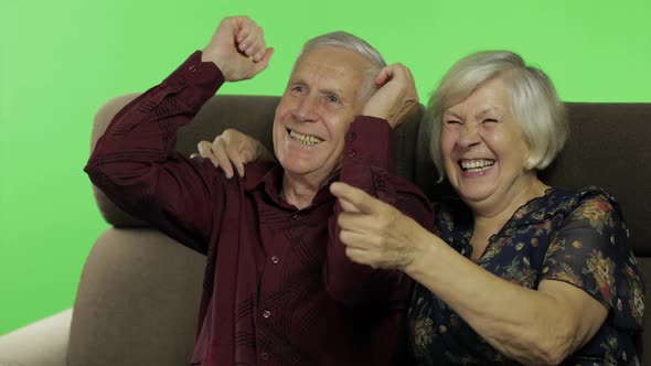 Senior Aged Man and Woman Sitting Together on a Sofa and Watching TV. Chroma Key