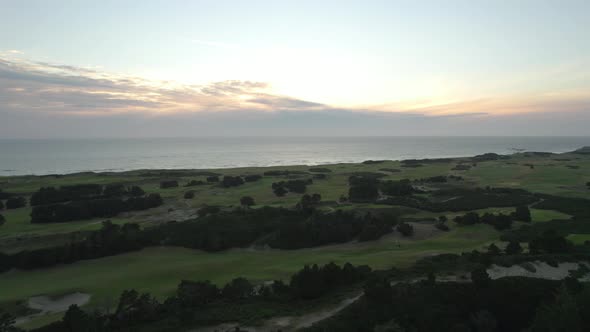 Aerial view of sunset above Pacific Ocean and Bandon Dunes Golf Resort in Oregon, USA. Coastal lands