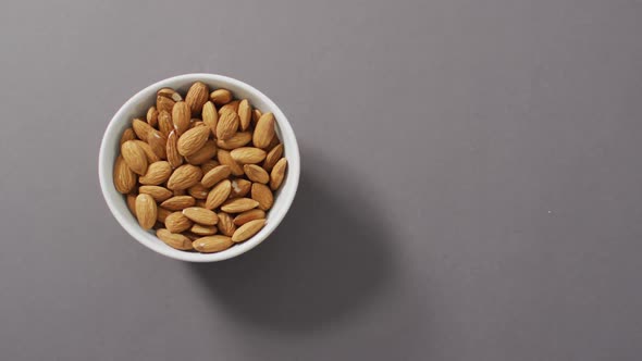 Video of fresh fruit almonds in a bowl on grey background