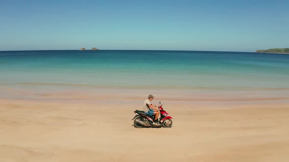 Man Driving a Motorcycle on Beach