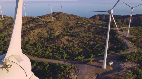 Wind turbines with blades in wind farm aerial view, motion drone