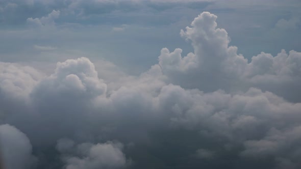 White Soft Fluffy Clouds Over the Green Landscape Aerial View From the Plane