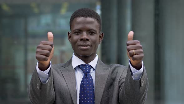 Success,winning. Young american african man making thumbs up- outdoor