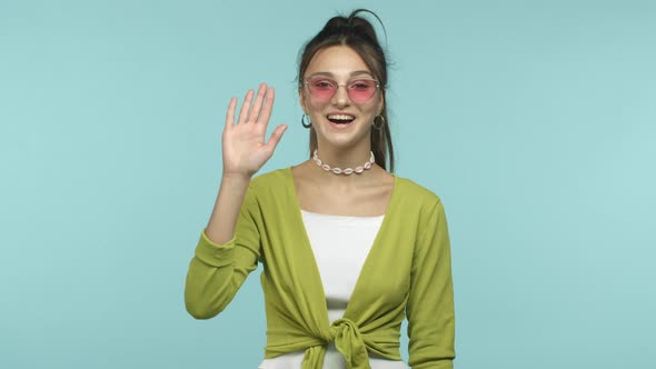 Slow Motion of Stylish Young Woman Saying Hi Waving Hand in Hello Greeting and Smiling Friendly