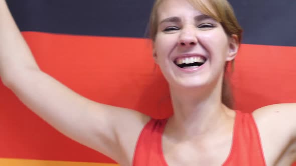 German Young Woman Celebrating While Holding the Flag of Germany in Slow Motion