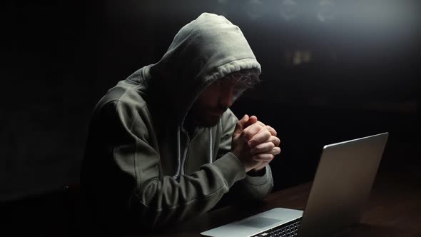 Thoughtful Hacker Man Looking at Laptop Screen and Working on Computer Thinking Solving Problem.