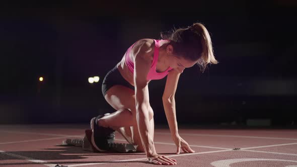 Woman Hand on Track As He Crouches in Starting Position at the Beginning of a Race