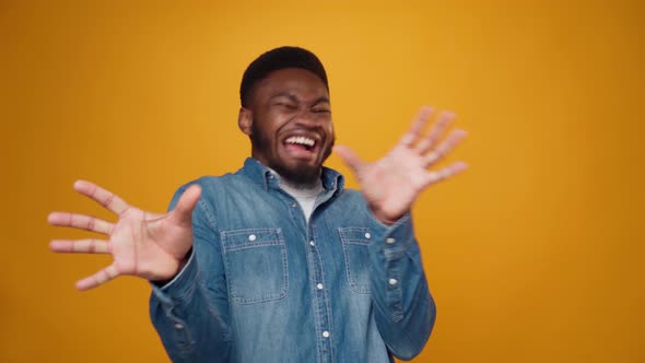 Worried Scared Young African American Man Against Yellow Background