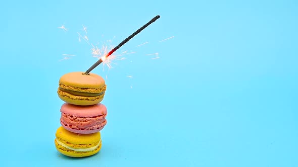 Stack of Delicious Macaron with Burning Sparkle on Blue Pastel Background. Celebrating Concept.