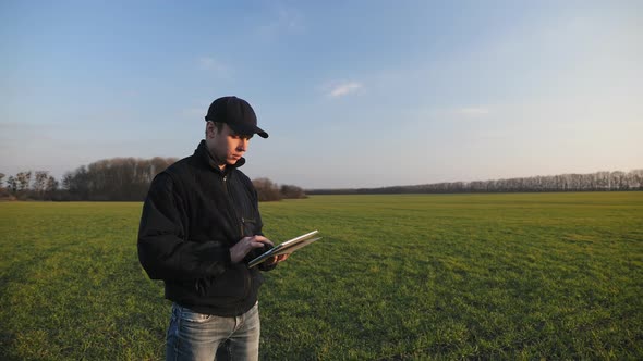 Male Farmer with Portable Tablet Computer in a Wheat Field