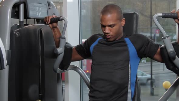 Male working out in gym on exercise machine