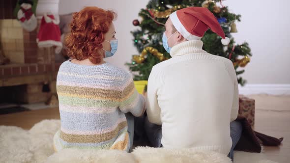 Back View of Adult Caucasian Couple in Covid19 Face Masks Looking at Each Other Sighing and Admiring