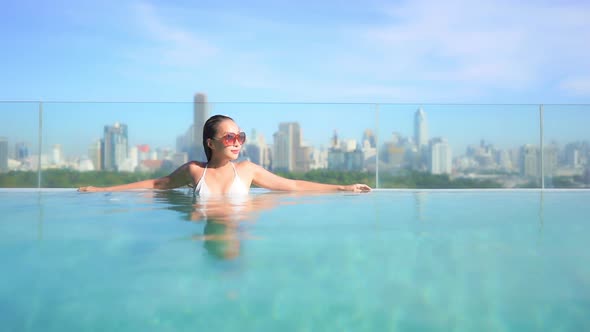 Young asian woman enjoy around outdoor swimming pool for leisure