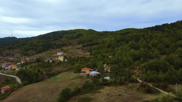 Steep green mountains, deep forest and mountain road, beautiful valley and village houses