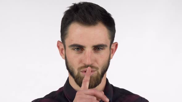 Attractive Bearded Man Shushing To the Camera with Finger To His Lips