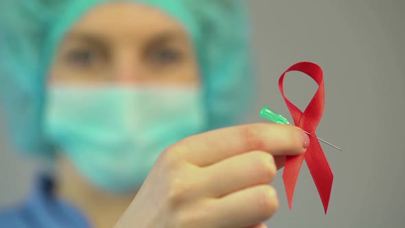 Female Doctor Holding Red Ribbon, International AIDS, HIV Awareness Symbol